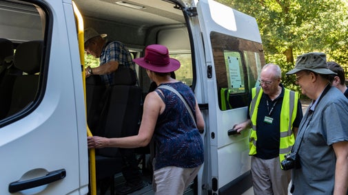 Visitors board a minibus.